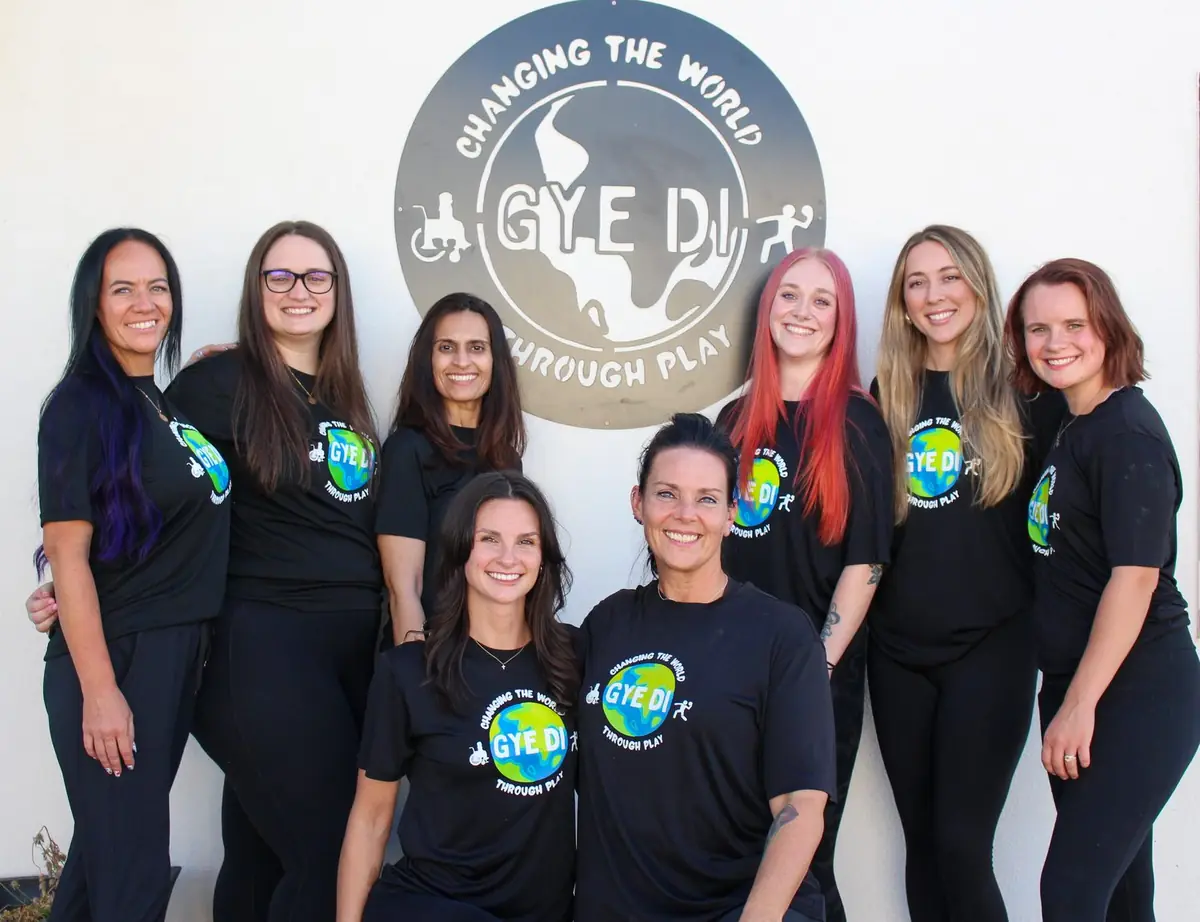 The Gye Di team together beneath the Gye Di logo